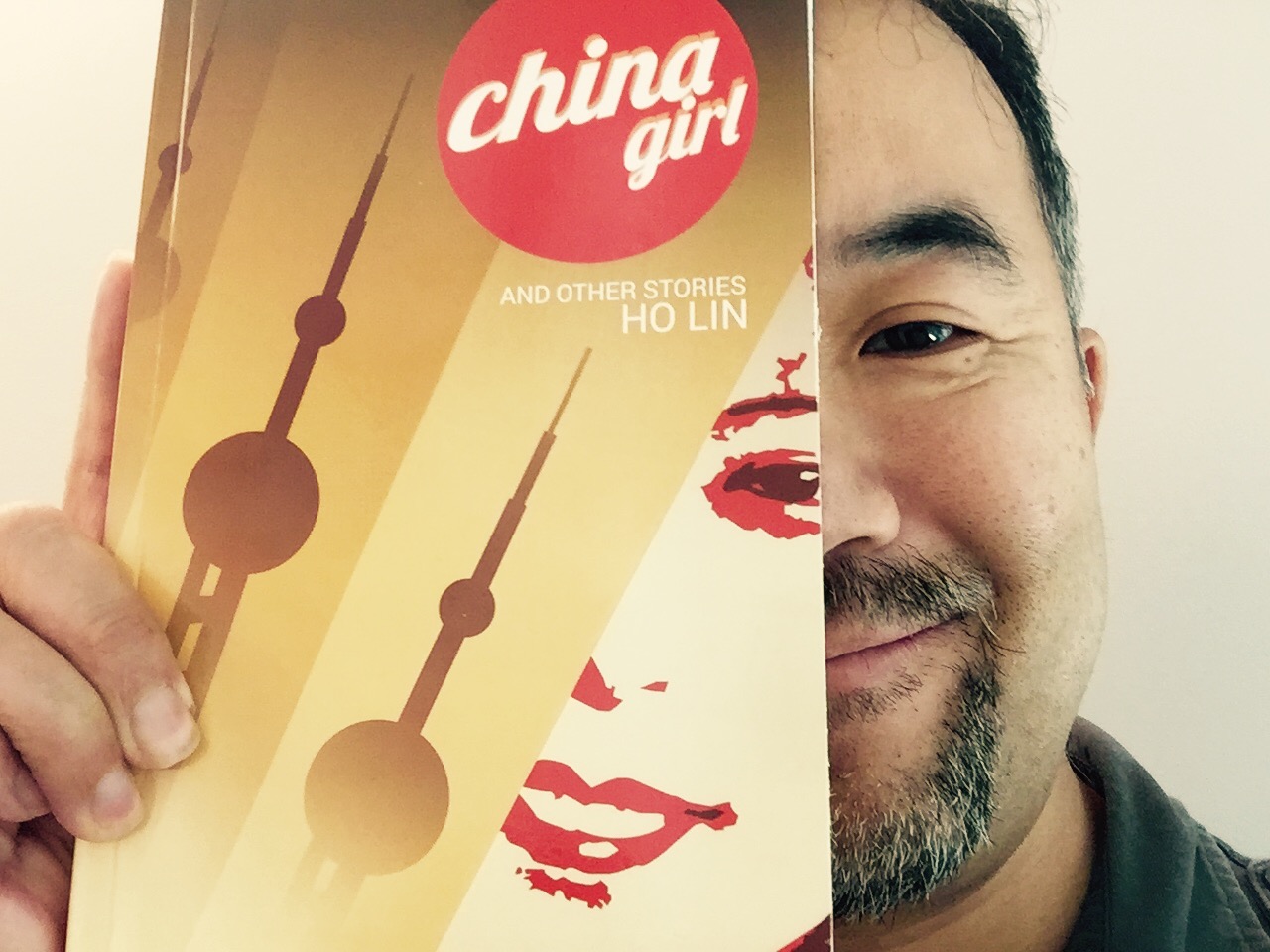 Ho Lin holding a copy of China Girl and Other Stories